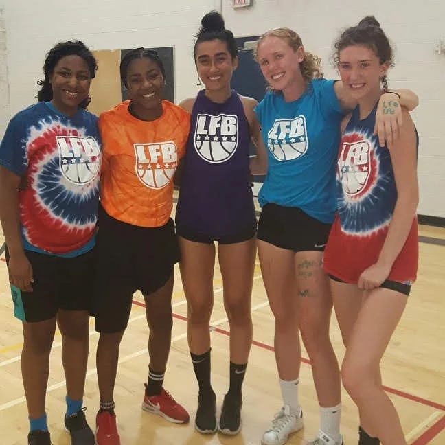 five teenage girls wearing t-shirts and shorts smile